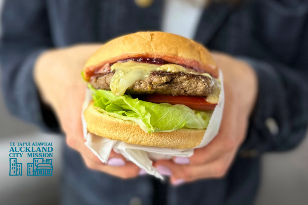 man holding a brie and cranberry Christmas Burger from Broadway Diner